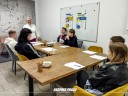 Zdjęcie 4: grupa osób siedząca przy stole podczas warsztatów pod tytułem: „Ucz się, zarządzaj, zarabiaj – wiedza Twoim atutem"