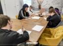 Zdjęcie 6: grupa osób siedząca przy stole podczas warsztatów pod tytułem: „Ucz się, zarządzaj, zarabiaj – wiedza Twoim atutem"