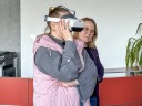 Doradca zawodowy asystuje osobie bezrobotnej podczas korzystania z gogli VR