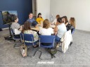 Zdjęcie 1: grupa osób siedząca przy stole podczas warsztatów.
