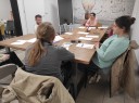 Zdjęcie 1: Grupa osób siedząca przy stole podczas zajęć grupowych pod nazwą „Jak i gdzie szukać pracy?"